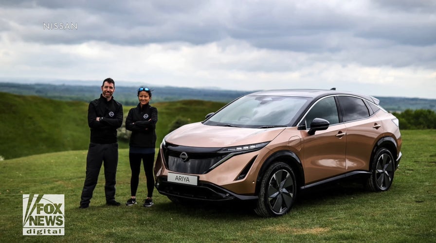 Married couple driving electric car from North to South Pole